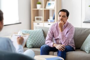 Man wondering how long alcohol stays in your system while being evaluated by therapist.